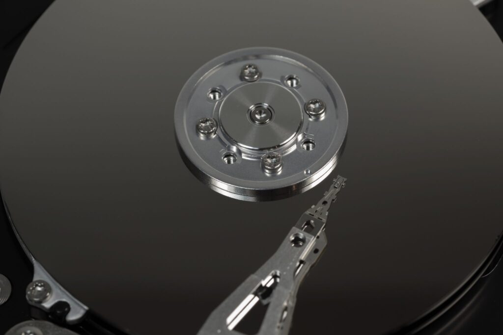 "Close-up view of a hard disk drive interior, showcasing the platter and read-write arm, illustrating data storage technology."