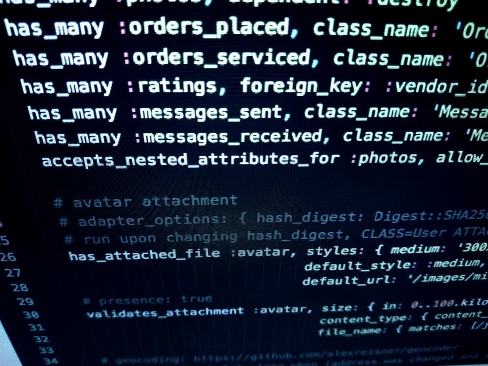 Close-up of computer code on a dark screen, featuring programming language and database commands for software development.