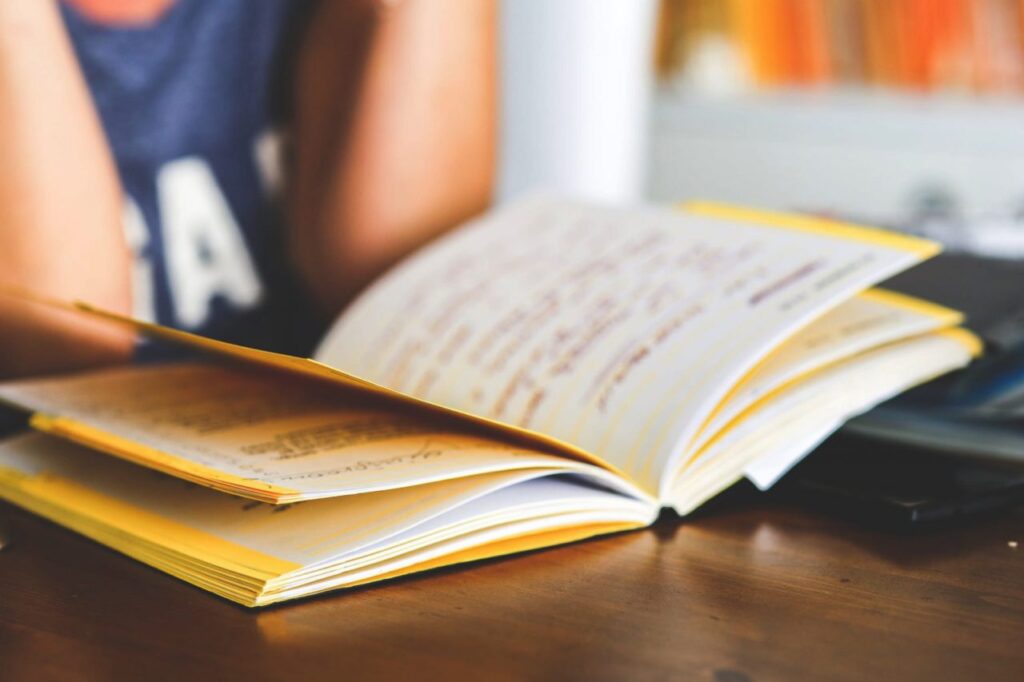 "Person studying with an open notebook on a desk, highlighting education and learning focus."