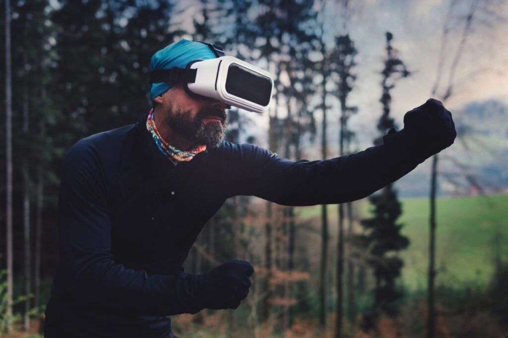 "Man wearing virtual reality headset in outdoor forest setting, experiencing immersive VR technology and augmented reality for outdoor activities."