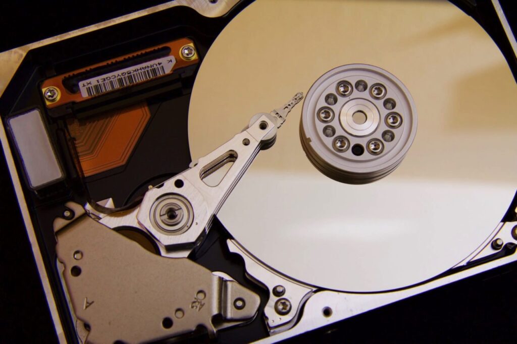 "Close-up of an open internal hard drive showing the shiny platters and read-write arm, illustrating computer storage technology."