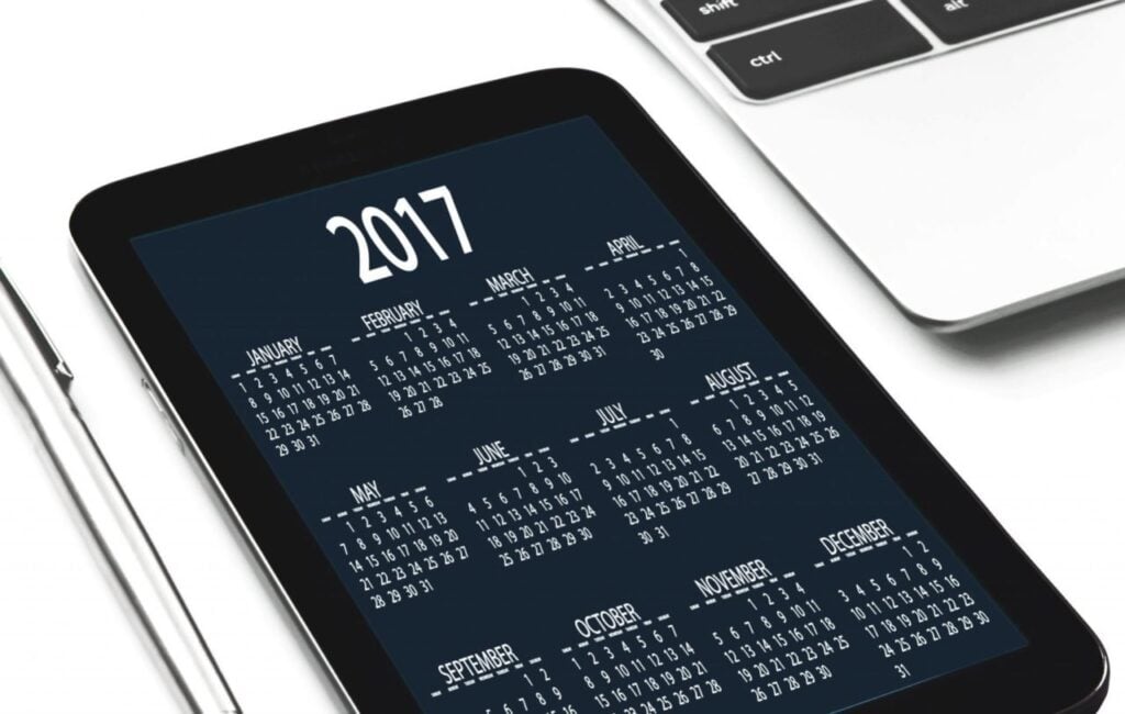 Digital 2017 calendar displayed on a tablet alongside a pen and a partial view of a laptop keyboard, representing technology and organization.