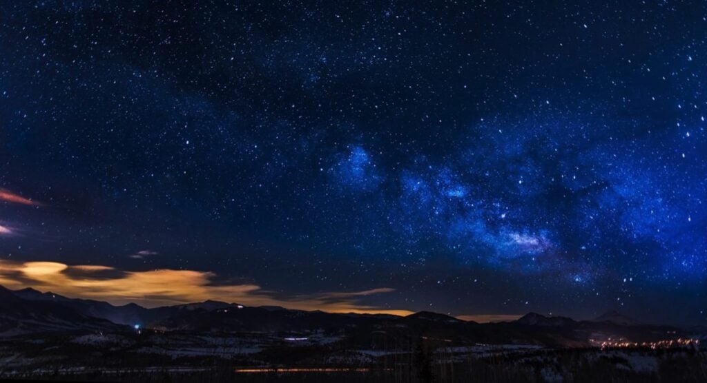 "Starry night sky with a view of the Milky Way galaxy over silhouetted mountain range, highlighting the beauty of astronomy and cosmic exploration."