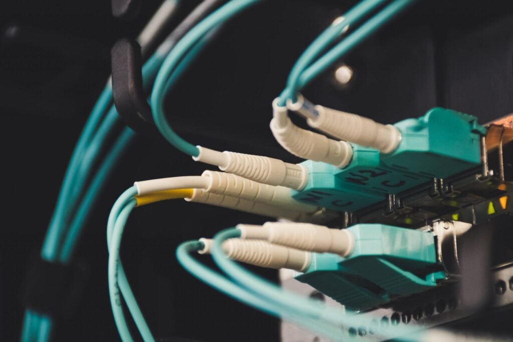 "Close-up of fiber optic cables connected to network equipment, illustrating high-speed internet connectivity and data transfer technology."