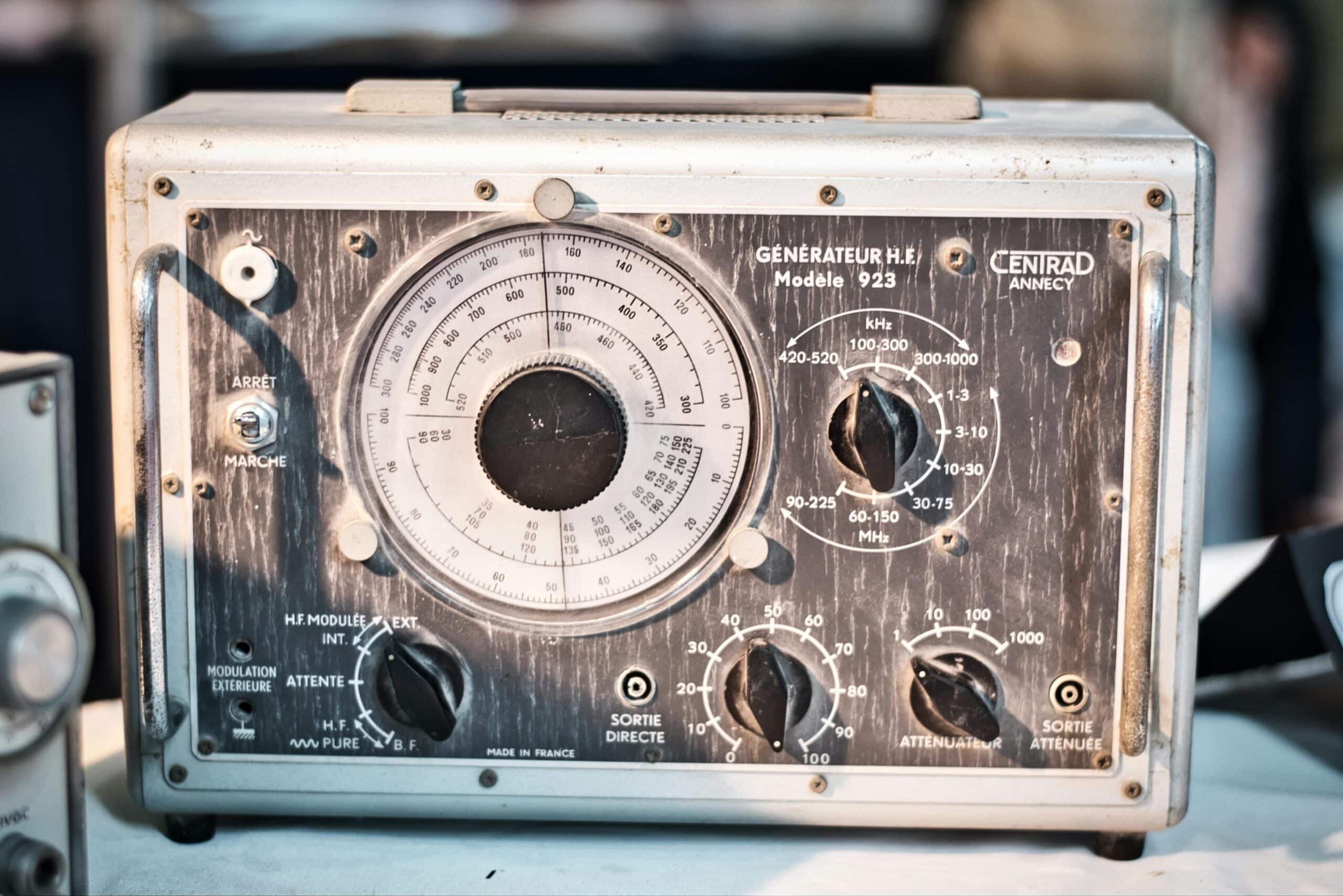 Close-up of a vintage analog frequency generator with knobs and dials for precise control.